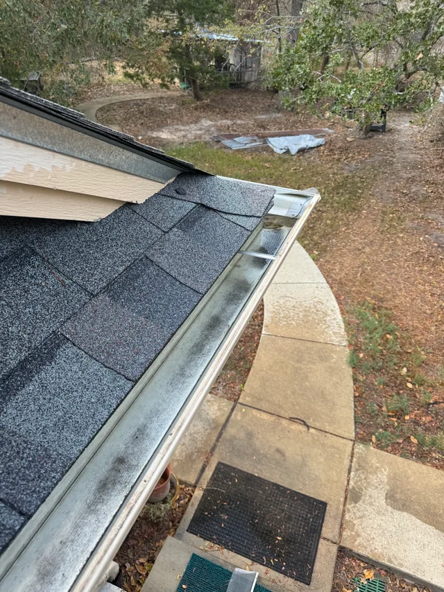 Open gutter channel along a roof edge after leaf and debris removal